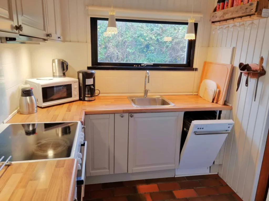 Køkken i sommerhus på Langeland med spiseplads og naturligt lys